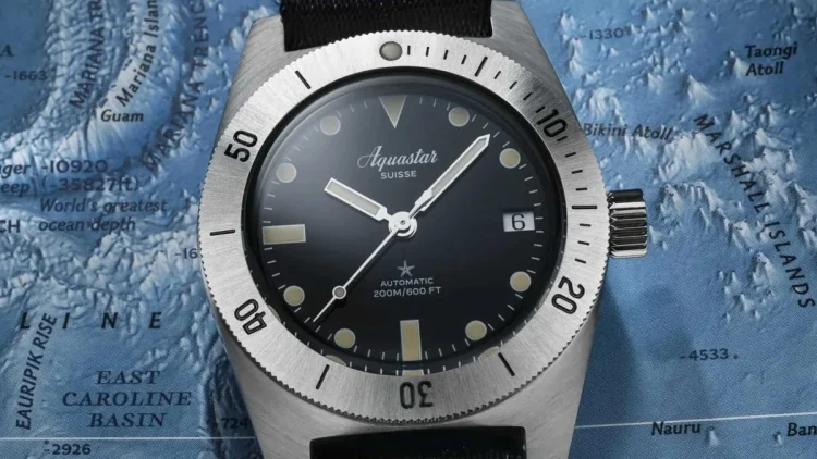 世界地図を背景にしたAquastar Model60。歴史的な探検を象徴するダイバーズウォッチのクローズアップ。